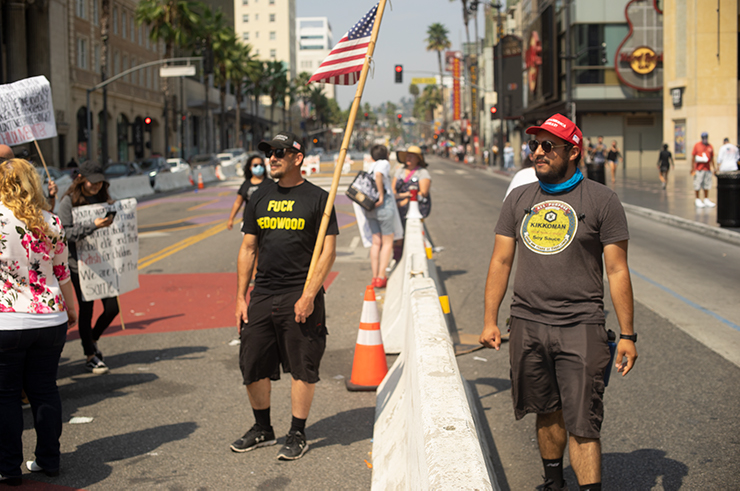 Two Trump supporters hang around a Black Lives Matter rally that the QAnon group marched through.