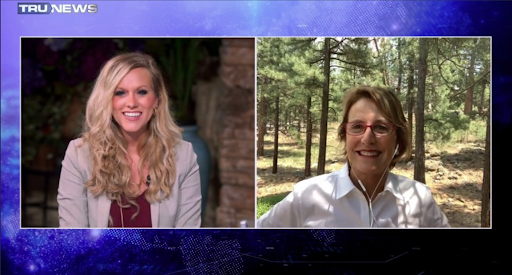 Sen. Wendy Rogers appears by video on TruNews, she’s standing outside surrounded by trees. Lauren Witzke smiles while interviewing her in the TruNews studio