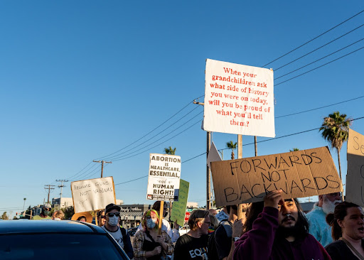 Protesters march through Escondido on June 25, 2022. One sign reads, “When your grandchildren ask what side of history you were on today, will you be proud of what you tell them?”