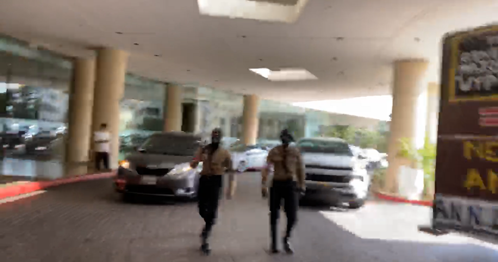 blurry image of two men in nazi uniforms with faces covered walking towards the camera