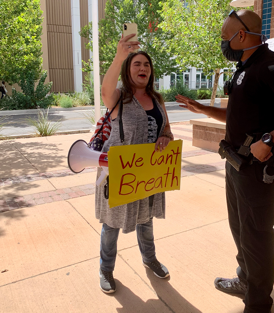 Anti-quarantine protest organizer and far-right blogger Rebekah Stevens carrying a misspelled sign. Photo by Bella Davis.