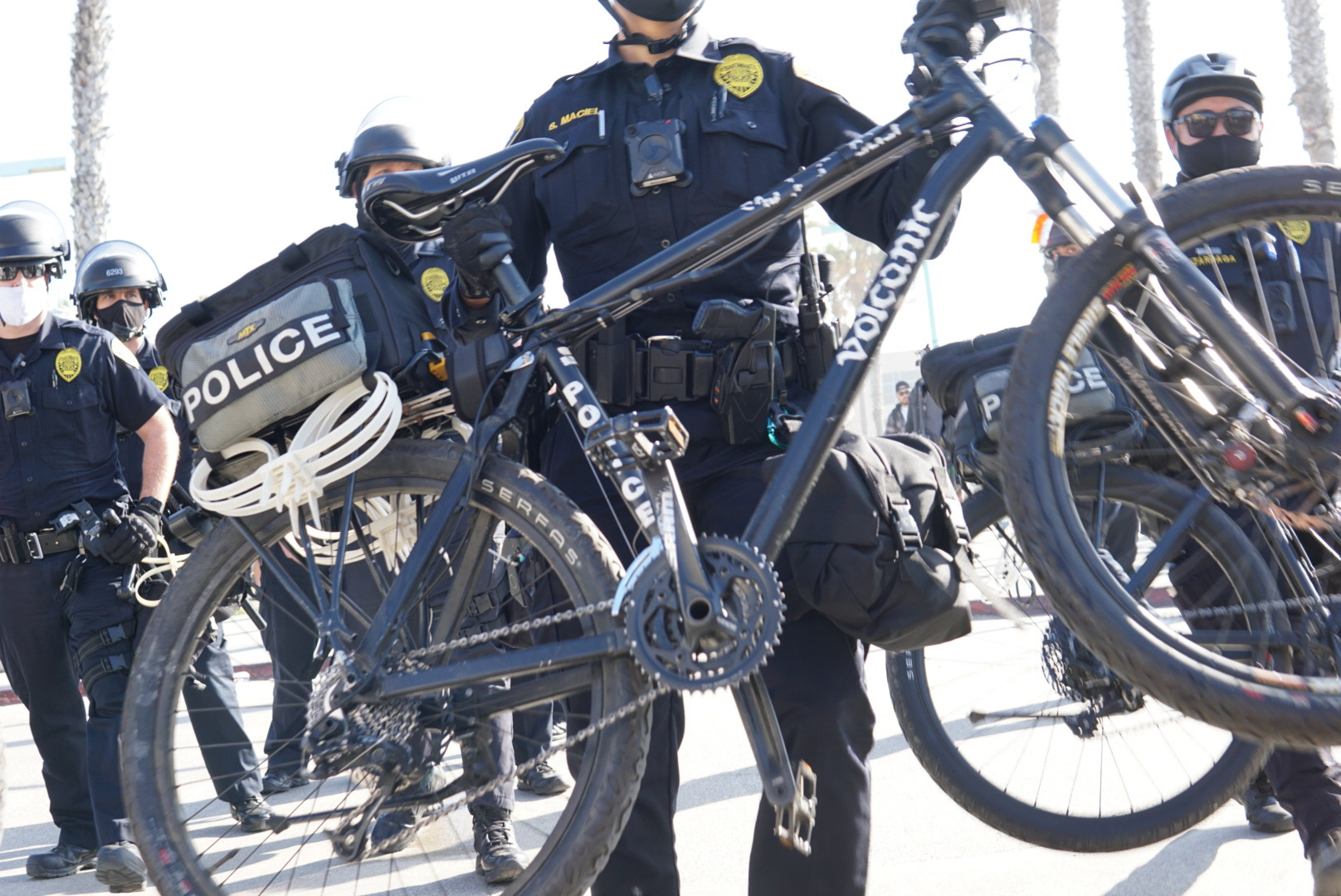 Bike cops line up and push forward.