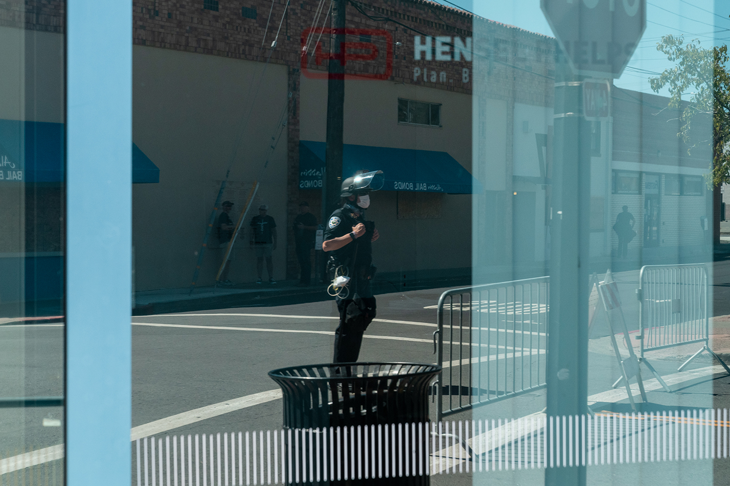 A police officer is seen in the reflection of a window in downtown Martinez, California during the “Zero Tolerance for White Supremacy” protest on Sunday, July 12, 2020.