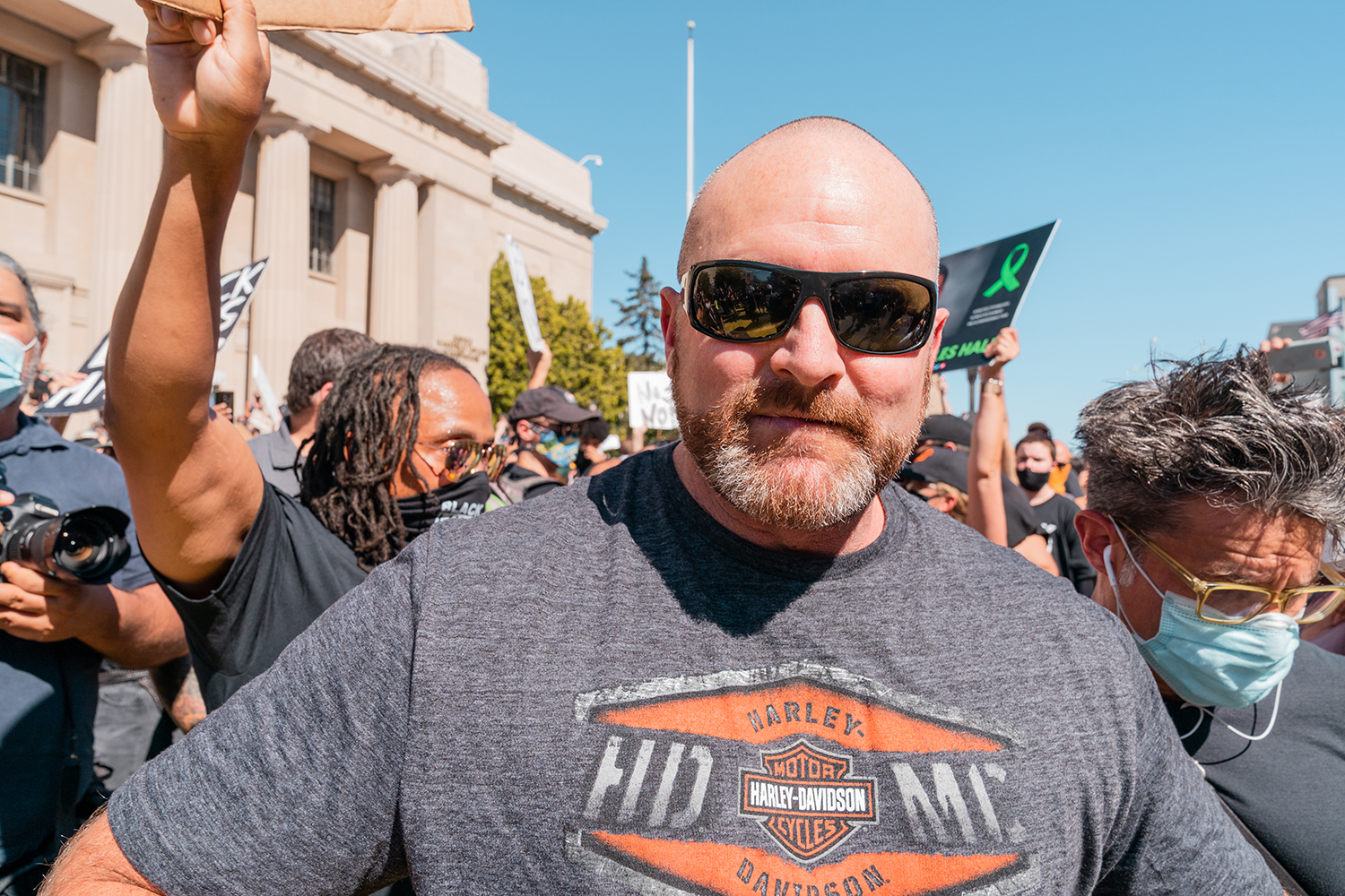 A counter-protester is escorted away by organizers and a pastor after provoking the crowd at the “Zero Tolerance for White Supremacy” protest in Martinez, Calif., on Sunday, July 12, 2020.