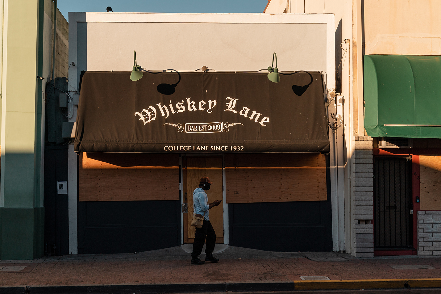 A person walks through the deserted downtown where most shops are boarded up in Martinez, Calif., on Sunday, July 12, 2020.