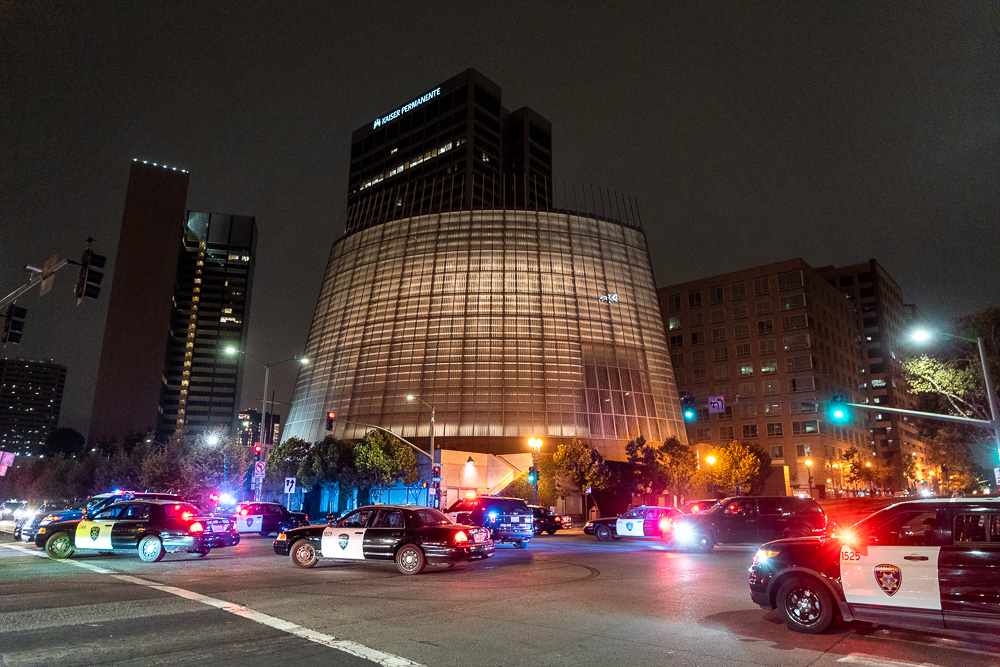 Dozens of police vehicles chase protesters onto Grand Avenue near Adams Point in Oakland, Calif., August 26, 2020.