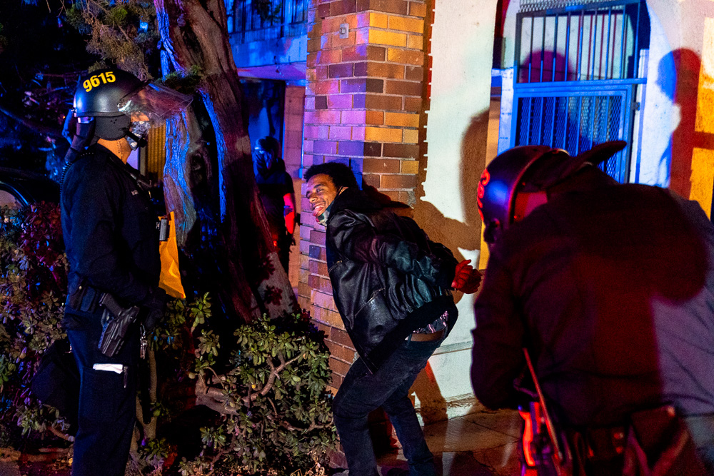 A man poses for a photo while being detained by Oakland police after officers dispersed the 'Justice for Jacob' protest in Oakland, Calif., August 26, 2020.