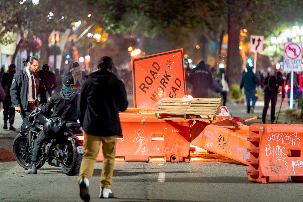 A roadblock made from construction barriers, signs, and pallets burns at Broadway Avenue and 21st Street as protesters calling for 'Justice for Jacob' march through the streets of Oakland, Calif., August 26, 2020. Jacob Blake was shot seven times in the back by police in Kenosha, Wis. — his shooting has reignited Black Lives Matter protests.