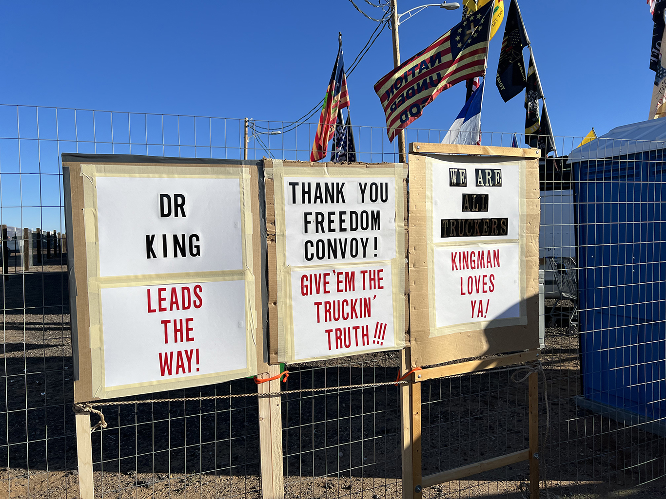 Protest signs that say 'Dr King leads the way, thank you freedom convoy give them the trucking truth, we are all truckers kingman loves ya'