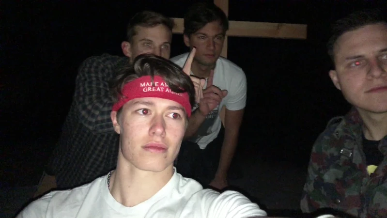 Ryan Sanchez (right) and Christian Secor (furthest back) along with two other unidentified Groypers pose with the wooden cross they raised in place of the Atascadero monolith