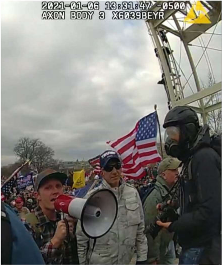 McHugh holding a megaphone in the crowd on January 6th from Police bodycam footage.'